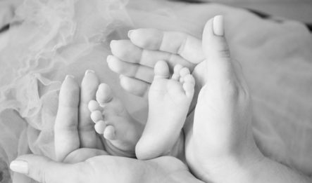 A woman holds her baby's feet